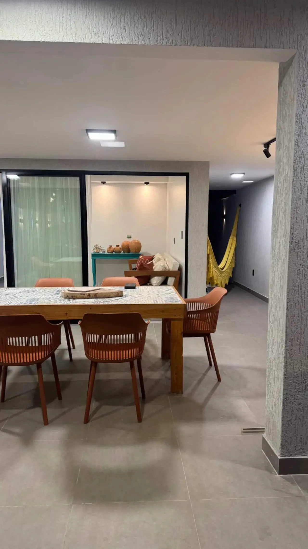 Sala de jantar com mesa de madeira e cadeiras em tom terracota