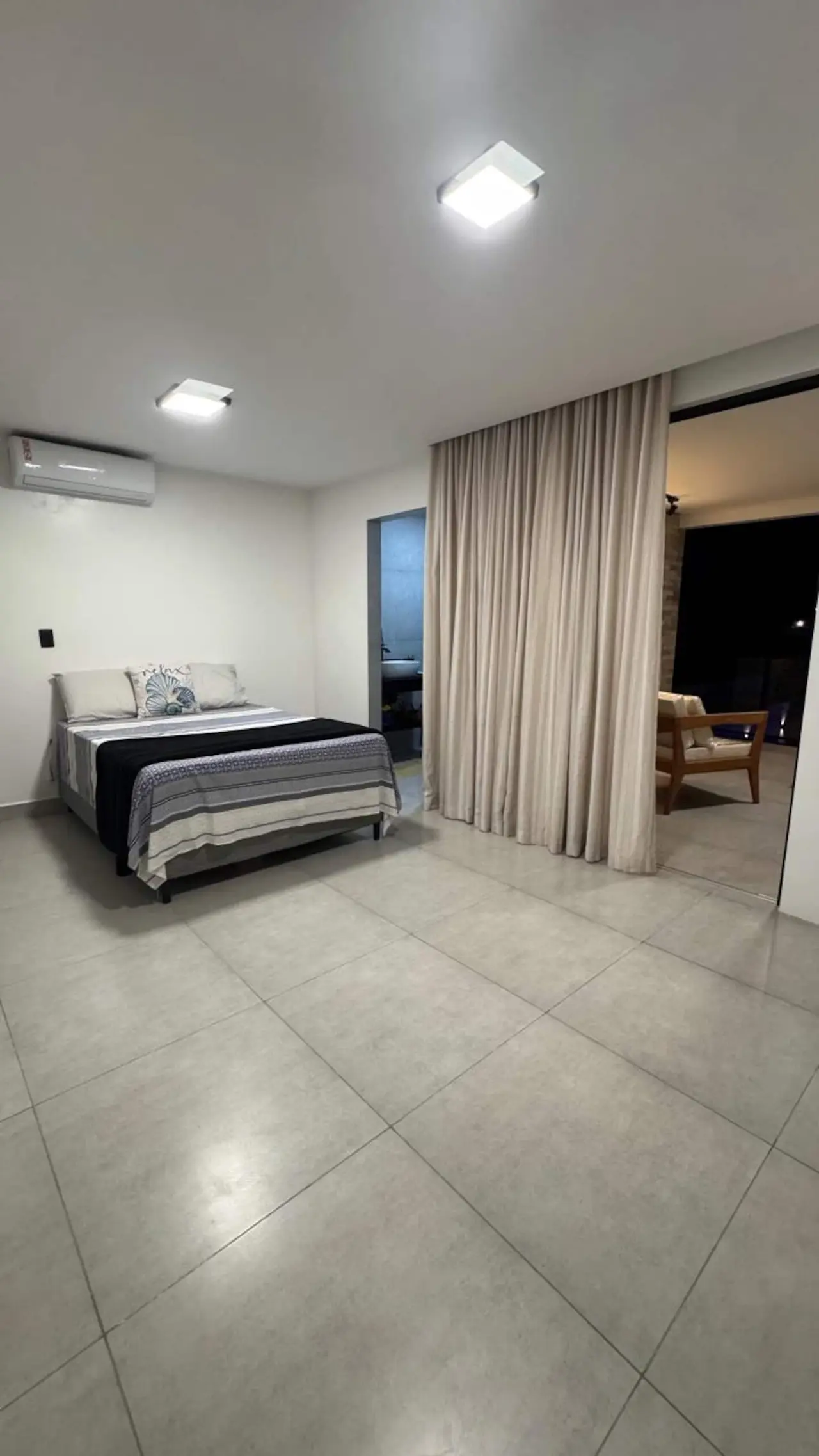 Quarto com cama de casal, ar-condicionado e cortina