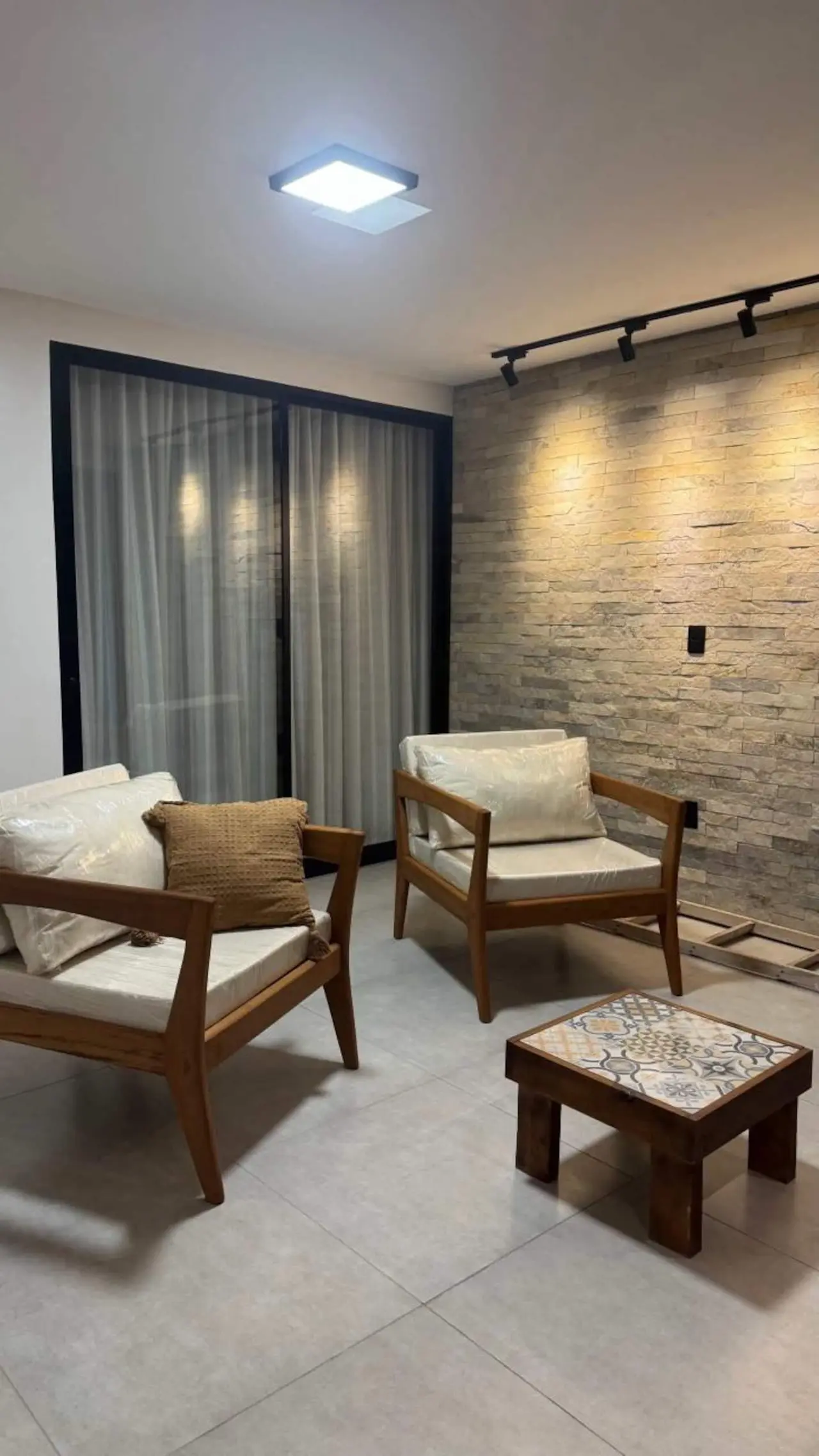 Poltronas de madeira e mesa de centro com azulejos